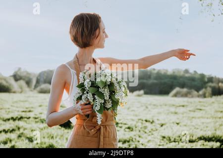 Portrait de la belle femme faisant couronne de fleurs pissenlits sur le champ de floraison. Style de vie d'été, amoureux de la nature et concept de liberté. Fleuriste Banque D'Images