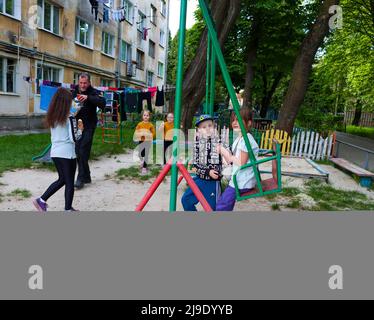 17 mai 2022, Lviv, Ukraine: Souse Denmark, co-fondateur de Veterans in Aid, un réseau britannique d'anciens membres du personnel de service de HM Forces travaillant ensemble pour atteindre un objectif commun de soutenir les personnes en cas de catastrophe et de conflit, Donne des friandises sucrées aux enfants qui jouent dans la jungle gym devant leur appartement à Lviv, Ukraine, le 16 mai, sur le chemin de la livraison de fournitures à l'orphelinat à côté. Les sirènes de RAID aérien s'en vont presque quotidiennement, alors que la Russie lance des missiles depuis le sud de l'Ukraine près d'Odessa, mais les enfants continuent à jouer des portes et la vie continue. (Image crédit : © Amy Katz/Z Banque D'Images