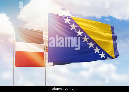 Ciel bleu ensoleillé et drapeaux de la bosnie et de la république dominicaine Banque D'Images