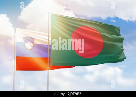 Ciel bleu ensoleillé et drapeaux du bangladesh et de la slovénie Banque D'Images