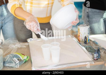 Résine époxy de couleur bleue différente dans la coupelle pour le moulage du bois stabilisateur, art abstrait. Processus de fabrication de l'accessoire à partir de résine. Mélange coloré de résine Banque D'Images