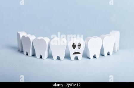 Dents en forme de sourire avec mauvais malade dent endommagée avec triste emoji sur fond bleu. Carie, maladie des gencives. Stomatology, problème dentaire, mauvaise hygiène buccale concept. Photo de haute qualité Banque D'Images