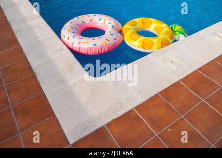 Flotteurs colorés dans l'eau d'une piscine, concept d'été Banque D'Images