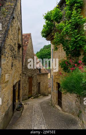 Beynac-et-Cazenac, France - 12 mai 2022 : rue pavée étroite avec maisons en pierre pittoresques dans le village historique de Beynac-et-Cazenac Banque D'Images