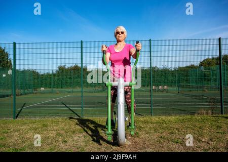 Femme âgée utilisant une machine d'exercice Caloo Cross Rider gratuite Banque D'Images