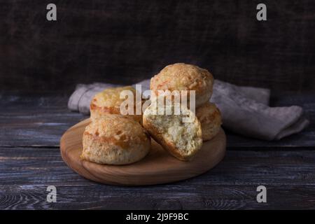 Scones maison fraîchement cuits avec du fromage et des herbes sur une table en bois. Petits pains traditionnels anglais Banque D'Images