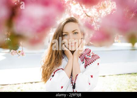 Portrait d'une femme mignonne dans le parc en fleurs de sakura. Concept de ressort. Banque D'Images