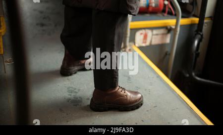 Chaussures brunes. Homme à chaussures. Homme en bus. Bottes d'automne. Banque D'Images