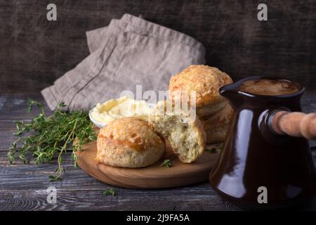 Scones frais maison avec fromage et herbes, café turk sur bois sur table en bois. Petits pains traditionnels anglais Banque D'Images