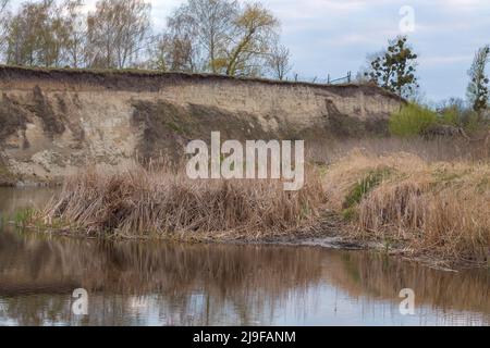 falaise près de la rivière. Glissement de terrain sur la rive de la rivière. Route dangereuse près de la rivière Banque D'Images