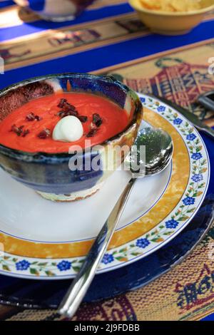 Gros plan d'un bol en céramique avec des salmorejo cordobes espagnoles fraîchement faites. Soupe froide de tomates, nappée de jambon serrano et d'œufs durs. Mise au point sélective Banque D'Images