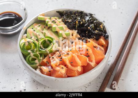 Saladier hawaïen de saumon avec avocat, concombre, riz et graines de sésame Banque D'Images