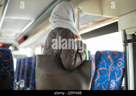 Fille en bus. Passager en transport. Transports publics en ville. Femme se tient près de la sortie du bus. Banque D'Images