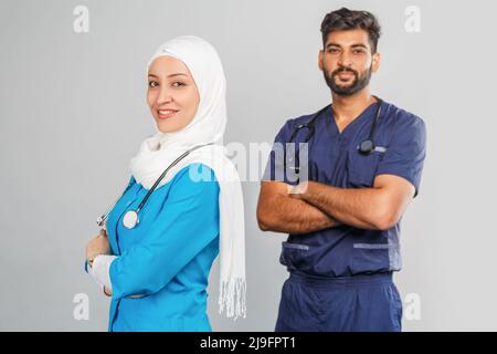 professionnel musulman médecin femme et assistant indien discuter des tâches. portrait de beaux travailleurs médicaux avec des stéthoscopes. Aide médicale, assurance Banque D'Images