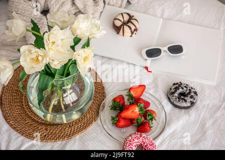 Composition maison avec bouquet de fleurs, fraises et beignets. Banque D'Images