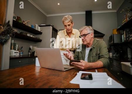 caucasien senior couple faisant le paiement en ligne à l'aide de la carte de crédit Banque D'Images