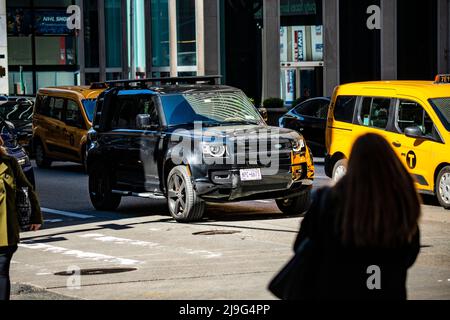 New Land Rover Defender à New York neben einem Yellow Cab taxi Banque D'Images