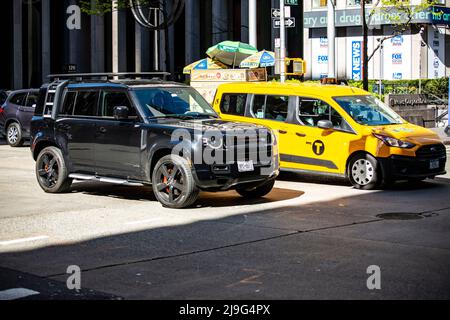 New Land Rover Defender à New York neben einem Yellow Cab taxi Banque D'Images