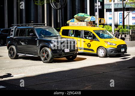 New Land Rover Defender à New York neben einem Yellow Cab taxi Banque D'Images