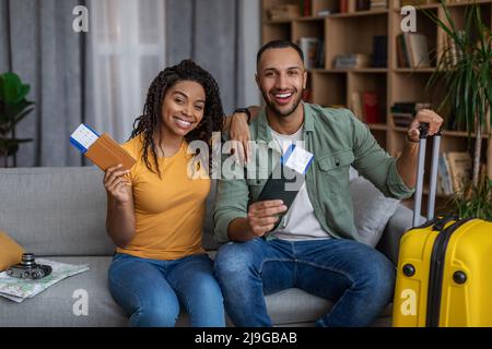 Concept de tours en famille. Conjoints noirs gaies avec valise, passeports et billets, prêts pour les vacances Banque D'Images
