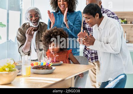 Bonne famille célébrant l'anniversaire de la fille à la maison Banque D'Images