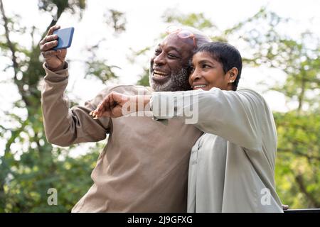 Couple souriant prenant le selfie avec un smartphone Banque D'Images