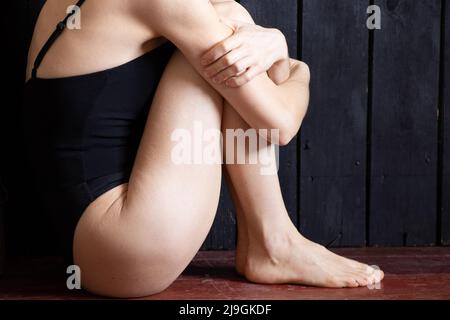 une fille est assise dans le coin de la pièce, effrayée par la dépression, la mauvaise humeur et la solitude Banque D'Images