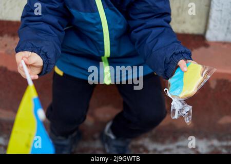 Un petit garçon patriotique détient le drapeau ukrainien et des biscuits symboliques. Tenez-vous avec l'Ukraine. Soutenir l'Ukraine. Arrêter le concept d'agression russe. Arrêter la guerre en Ukraine. Priez pour l'Ukraine Banque D'Images