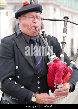 Un joueur joue des cornemuses traditionnelles sur Westminster Bridge, Londres, Angleterre, Royaume-Uni. Banque D'Images