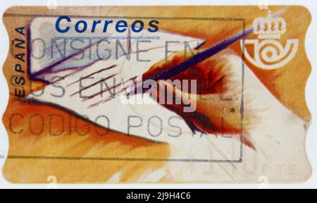 Photo d'un timbre-poste espagnol avec l'image d'une main tenant un stylo écrivant une lettre Banque D'Images