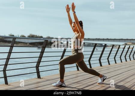 Jolie jeune femme de sport qui fait de l'exercice sur une promenade en bord de rivière Banque D'Images