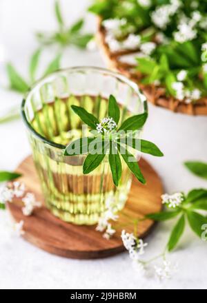 Limonade sucrée traditionnelle de Woodruff dans un verre avec une feuille fraîche sur une montagne en bois. Banque D'Images