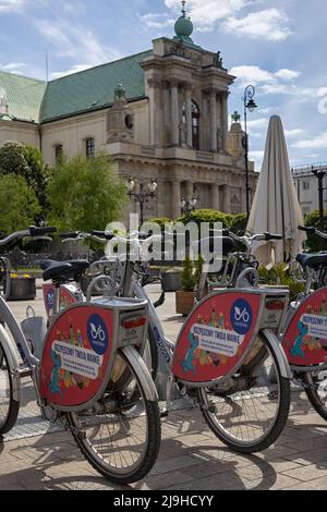 VARSOVIE, POLOGNE - 17 MAI 2022 : Station de location de vélos Nextbike avec l'église Carmélite en arrière-plan Banque D'Images