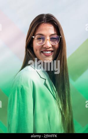 Femme souriante aux cheveux longs bruns portant un blazer Banque D'Images