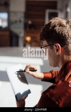 Homme d'affaires avec écriture numérique au stylo sur tablette PC dans le bureau Banque D'Images