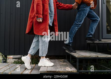 Couple tenant les mains qui entrent dans la maison Banque D'Images