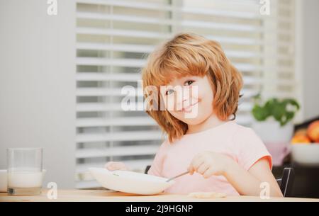 Les enfants mangent. Petite soupe saine pour les garçons affamés avec une cuillère. Banque D'Images