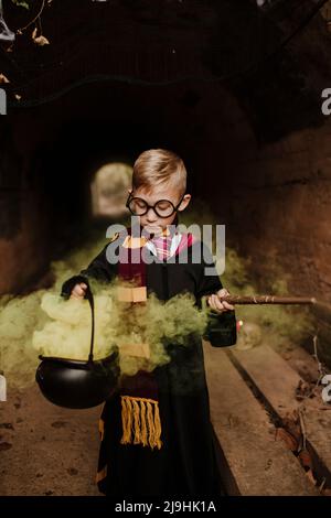 Garçon tenant le chou-fleur magique avec la fumée jaune portant le costume dans le tunnel Banque D'Images