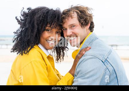 Couple souriant touchant les têtes en regardant l'épaule ensemble Banque D'Images