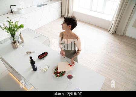 Femme préparant une salade de légumes dans la cuisine à la maison Banque D'Images