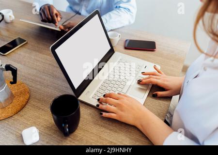 Femme travaillant sur un ordinateur portable assis à une table à manger Banque D'Images
