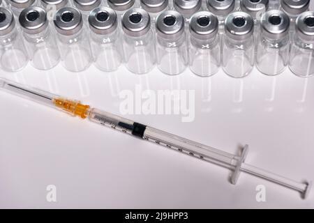 Couverts de vaccination devant une série d'ampoules neutres Banque D'Images