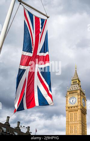 Un drapeau de l'Union Jack admirablement éclairé sur la place du Parlement à Londres, photographié devant Big Ben en mai 2022. Banque D'Images