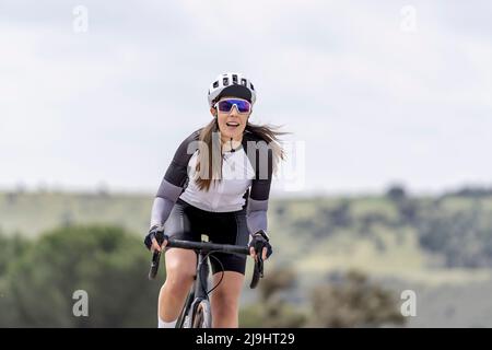 Cycliste souriant portant un casque de sport et des lunettes de soleil à vélo Banque D'Images