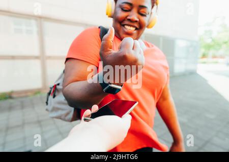 Bonne femme qui fait le paiement par Smart Watch Banque D'Images