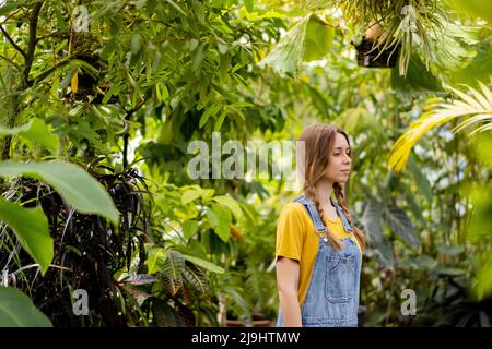 Jeune femme attentionnée avec des cheveux bruns dans le jardin Banque D'Images