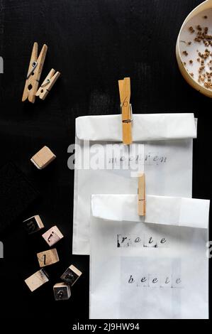 Sacs de graines blanches fermés avec des épingles à linge sur la table noire Banque D'Images