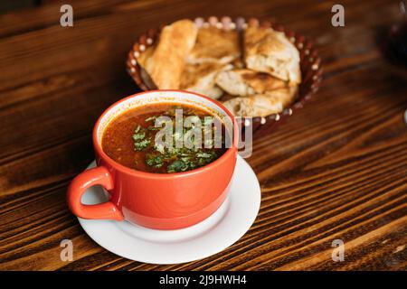 Cuisine géorgienne. Kharcho ou Harcho est une soupe géorgienne traditionnelle contenant du bœuf, du riz, de la purée de prunes aux cerises et des noix hachées - Juglans regia. Le Banque D'Images