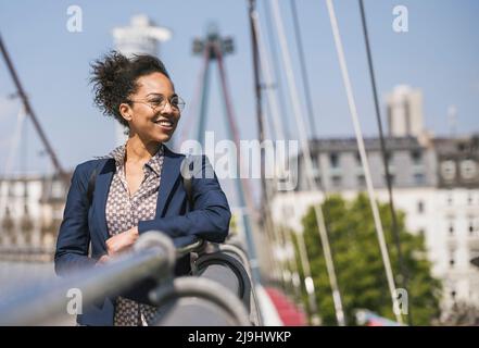 Femme d'affaires contemplative penchée sur une rampe Banque D'Images