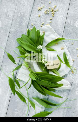 Photo studio de feuilles de ramson fraîches et de pignons couchés sur une surface en bois Banque D'Images